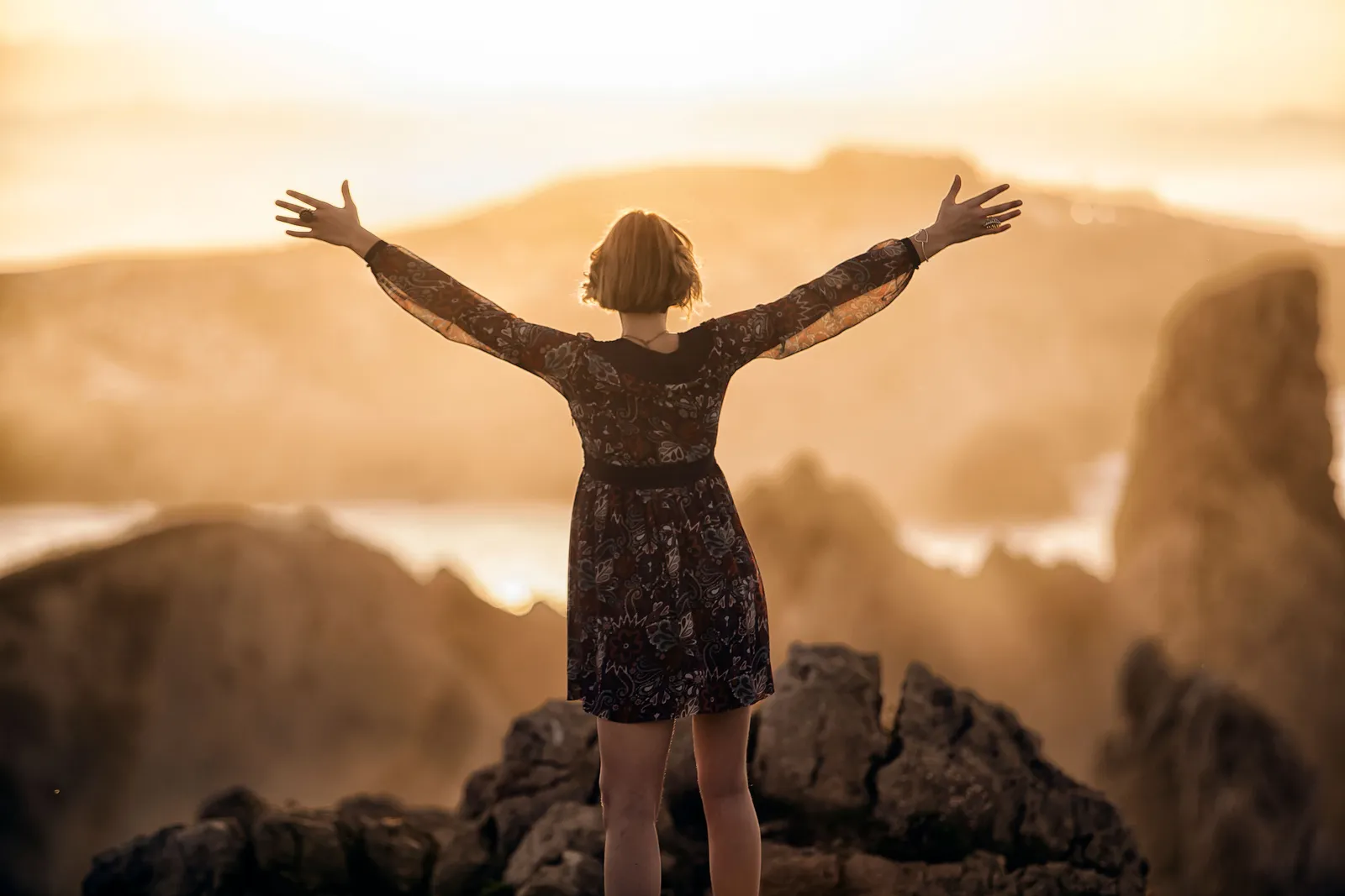 Femme qui se libère du passé, bras ouverts vers la lumière